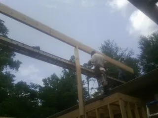 Carpenter setting a ridge beam over a new addition frame — Ice Dam Removal by Roofing Brothers in Pen Argyl