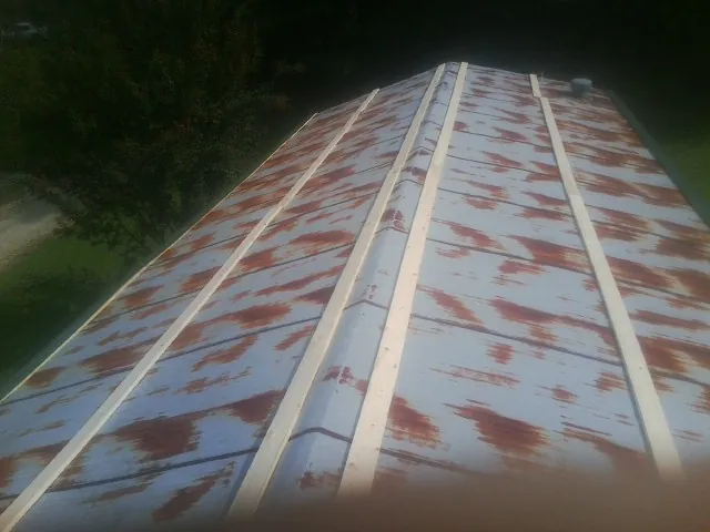 Rusted metal roof panels with new wood purlins before replacement — Storm Damage Roof Repair in Pen Argyl by Roofing Brothers