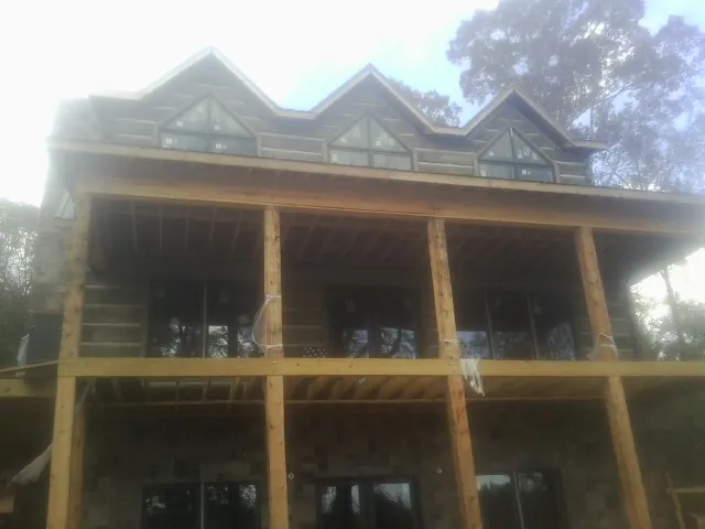 Dormers and porch framing on a large log home under construction — Roof Coating work by our crew in Pen Argyl