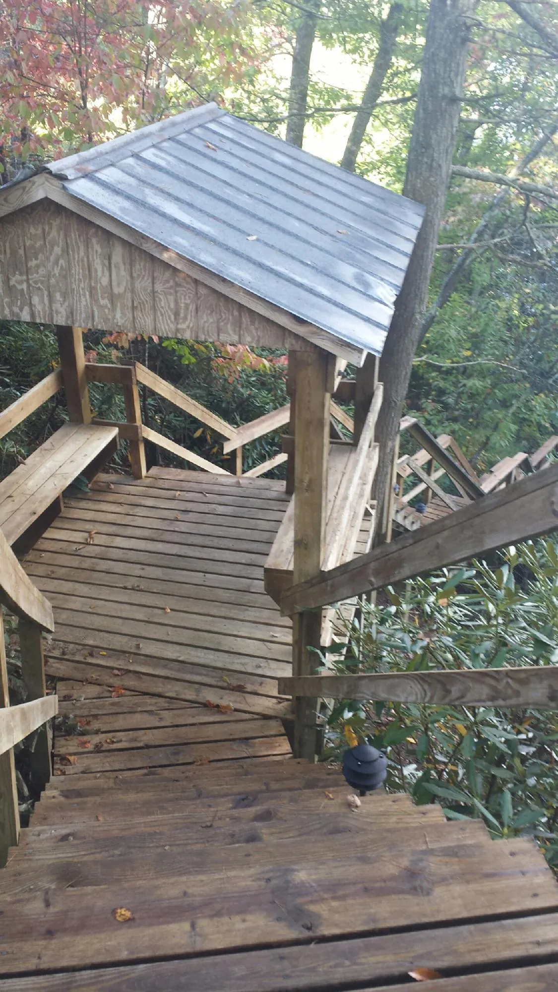 Metal roofed shelter over wooden steps on a wooded walkway — Skylight Repair & Installation work by our crew in Pen Argyl