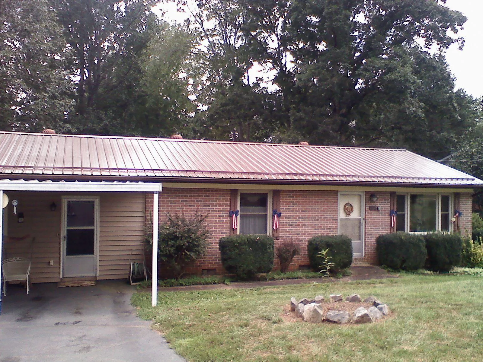 Bronze metal roof and carport on a brick ranch home — Roof Repair work by our crew in Pen Argyl